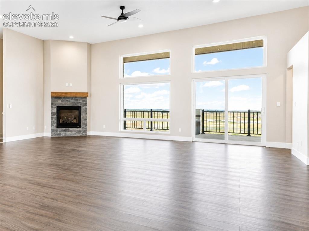 Image 15 of 40: Spacious interior featuring wood-finish flooring, a stone fireplace with a