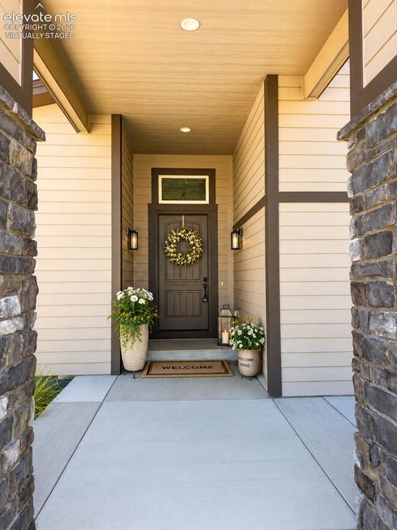 Image 2 of 40: Virtually Staged Inviting entry featuring a solid paneled door with transom