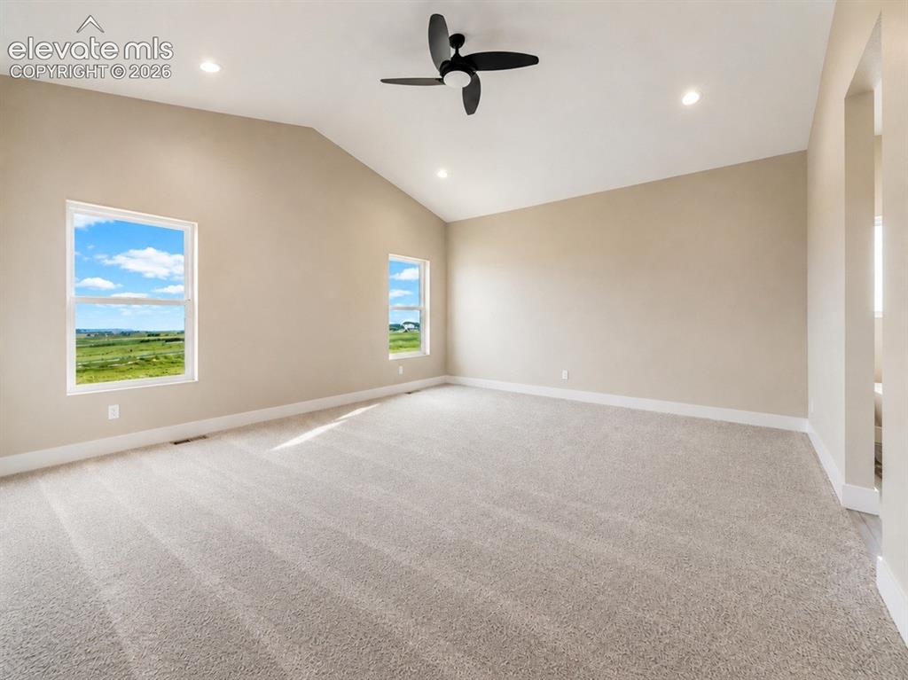 Image 21 of 40: Spacious room featuring a vaulted ceiling with a ceiling fan, recessed ligh