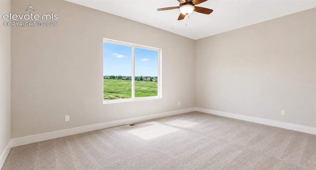 Image 25 of 40: Spacious room featuring neutral carpeting, light-toned wall paint, and whit