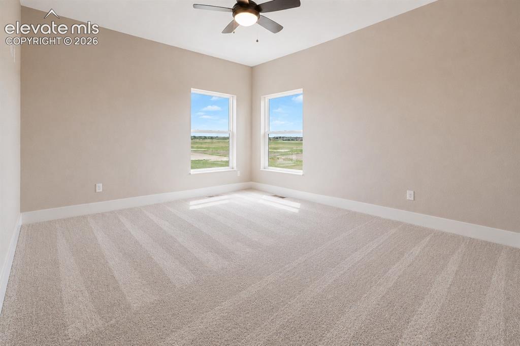 Image 27 of 40: Spacious room with plush light-toned carpeting and neutral wall tones