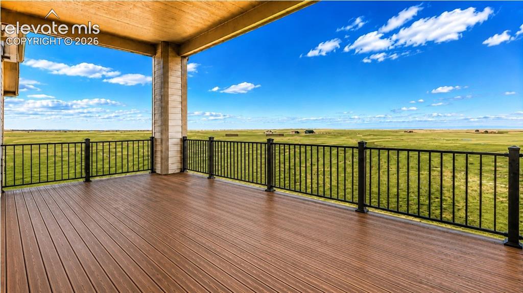 Image 32 of 40: Expansive covered deck featuring wood-finish composite decking and black me