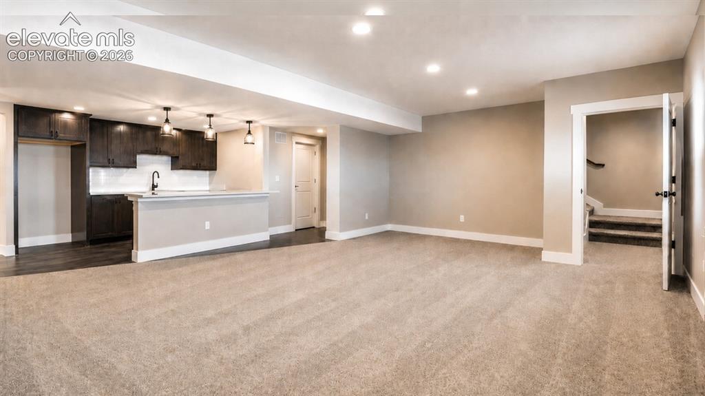 Image 34 of 40: Expansive open-concept room featuring plush carpeting, recessed lighting, a