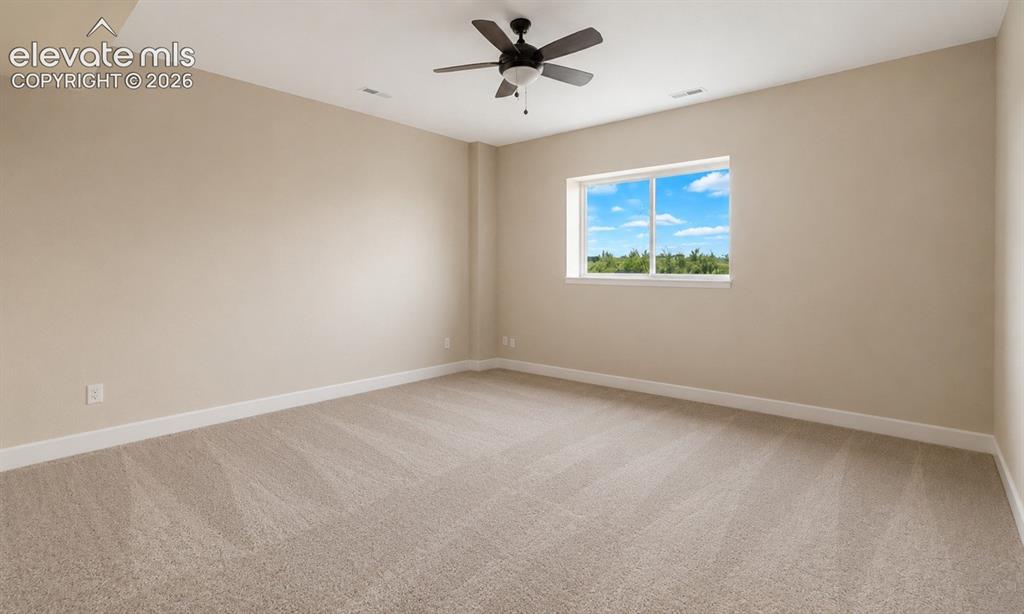 Image 40 of 40: Spacious room featuring neutral carpeting, light-toned walls, and white tri