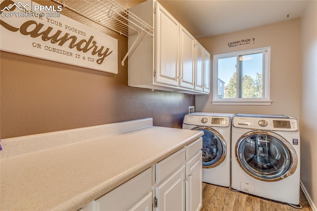 Image 13 of 31: Conveniently located upper laundry room with cabinet space, washing machine