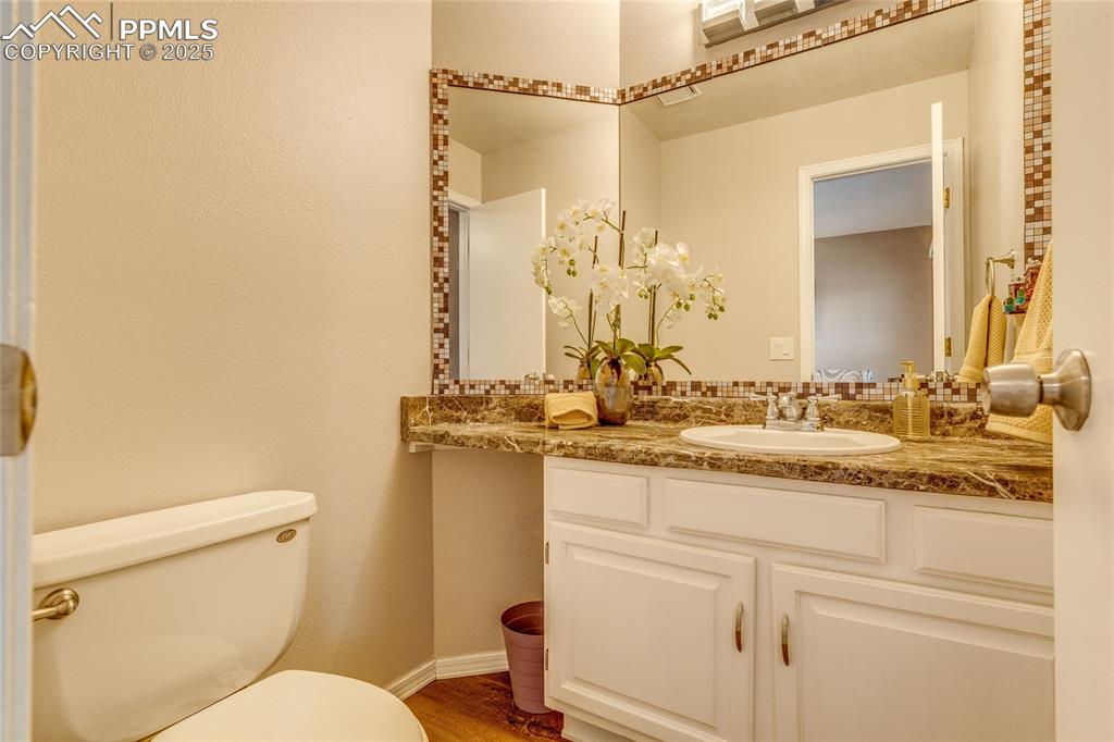 Image 22 of 31: Main level half bath featuring toilet and vanity