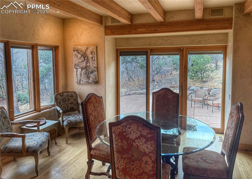Image 4 of 20: Dining room featuring a textured wall, beam ceiling, walkout to wonderful p