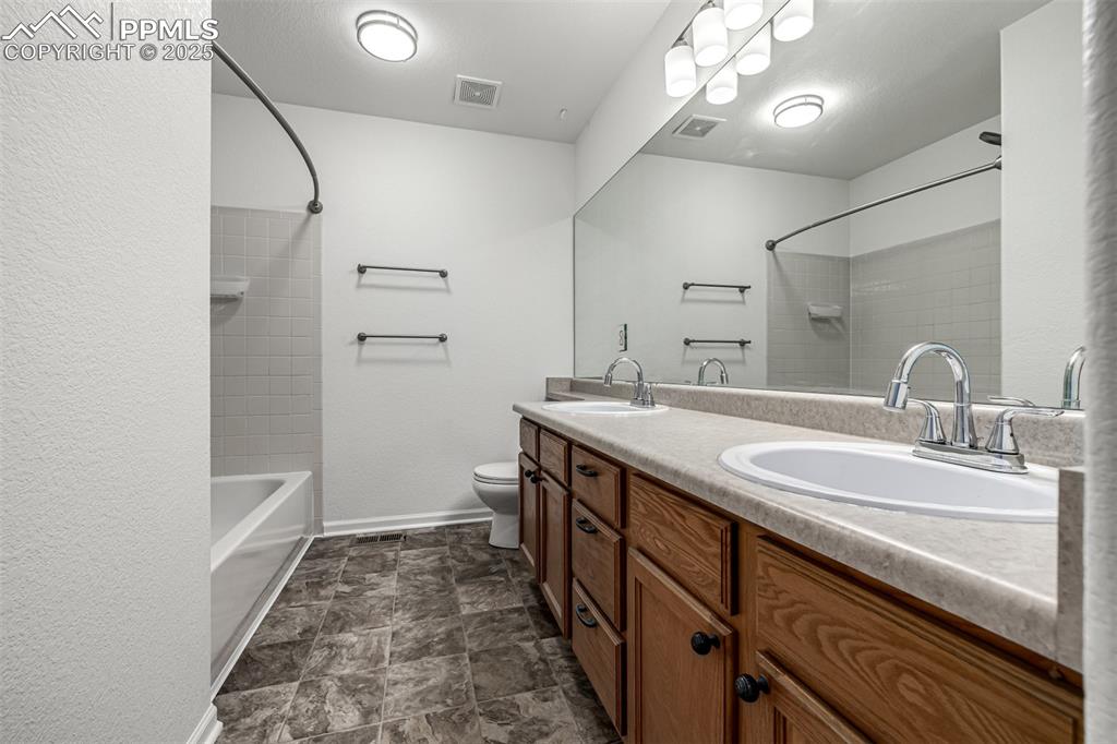 Image 23 of 35: Upstairs secondly bedroom with dual sinks and a large vanity