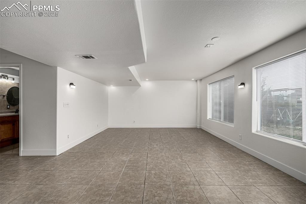 Image 26 of 35: Enjoy the spacious media room or secondary living space in the walk out bas