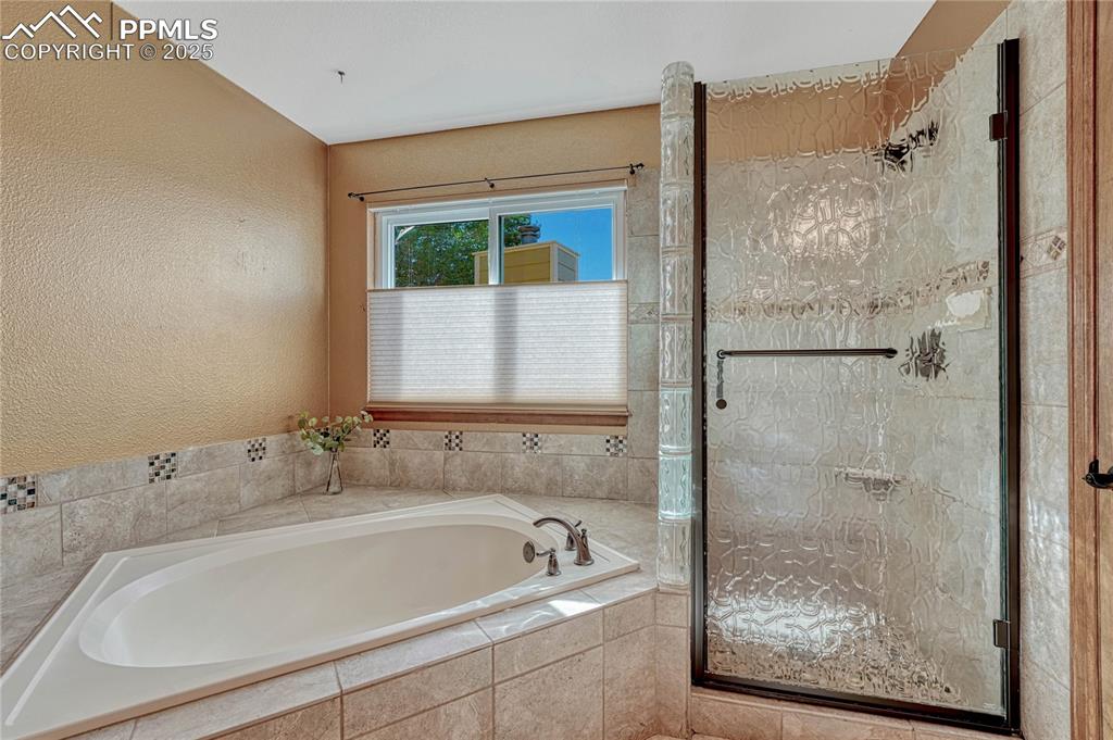 Image 11 of 48: Primary bath with soaking tub and tiled shower