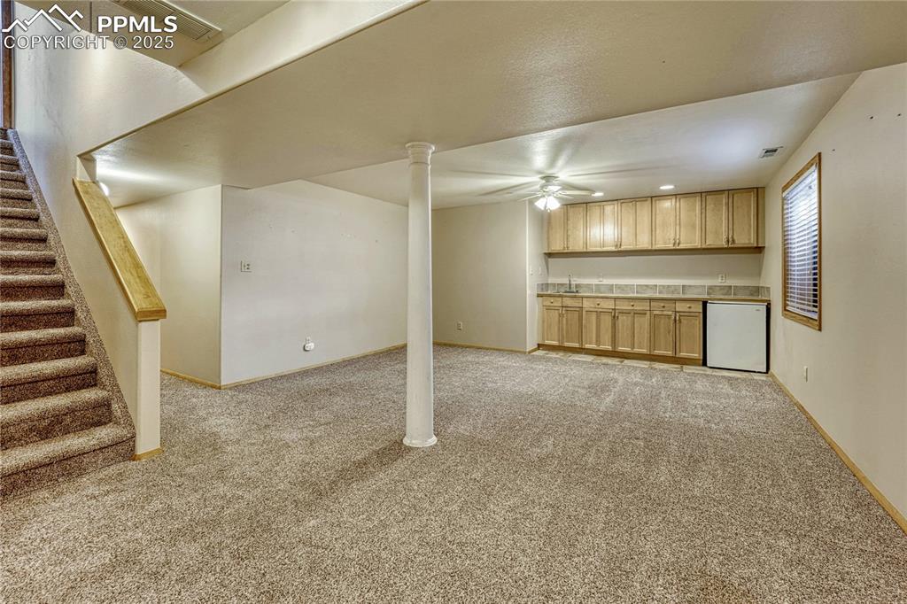 Image 12 of 48: Finished basement with wet bar and two additional bedrooms