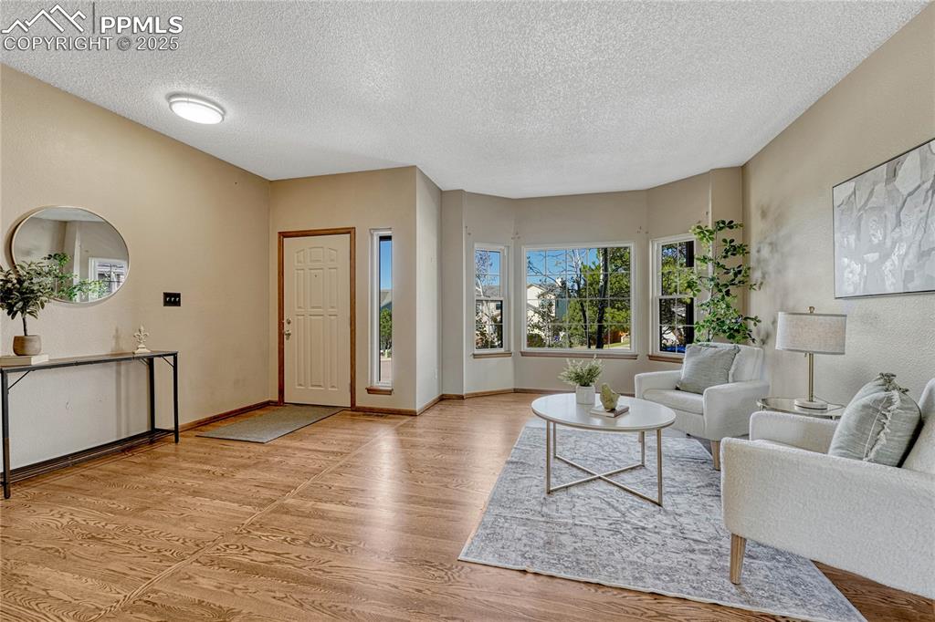 Image 19 of 48: Back inside, view of the bright living room and entry