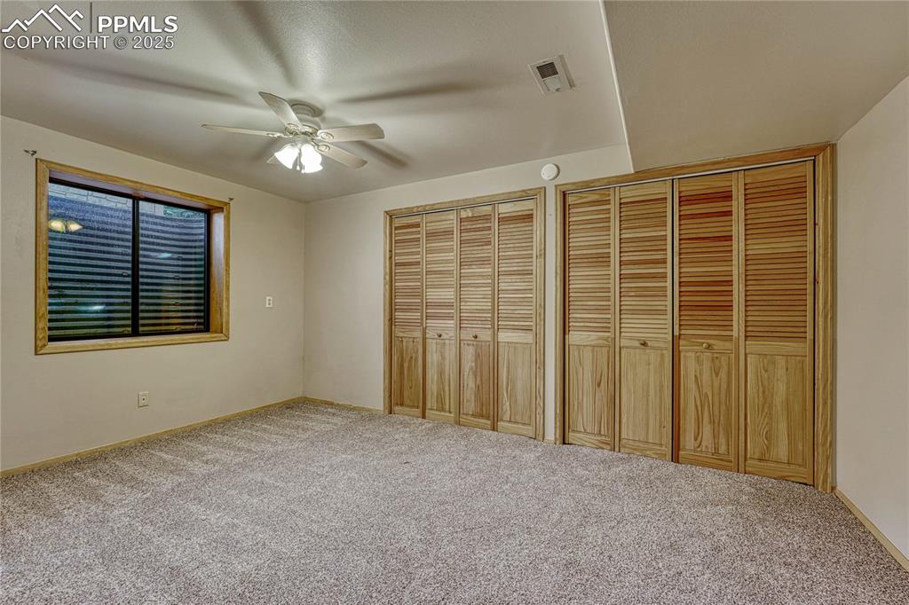Image 40 of 48: Large (non-conforming) Bedroom #4 with ceiling fan and double closets