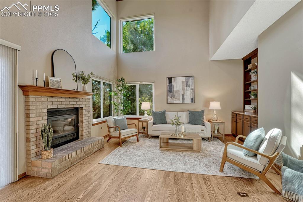 Image 7 of 48: Family room with vaulted ceilings, a fireplace, built-in shelving and cabin