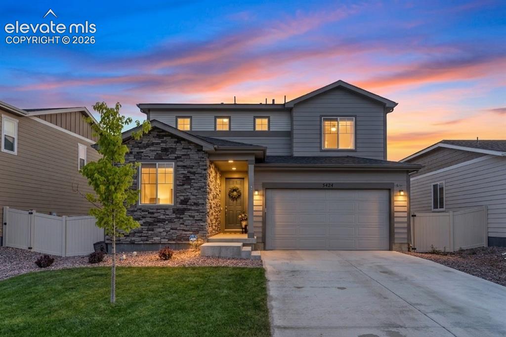 Image 1 of 33: Two-story residence featuring a mixed-material facade with stone veneer and