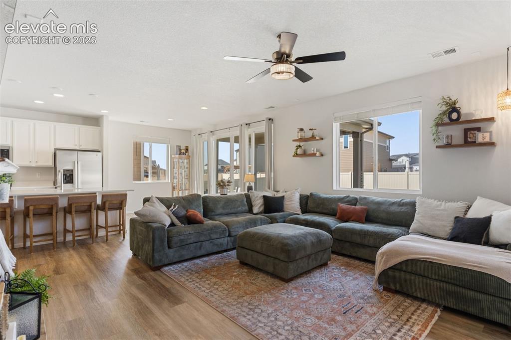 Image 10 of 33: Open-concept living area featuring wood-finish flooring, recessed lighting,