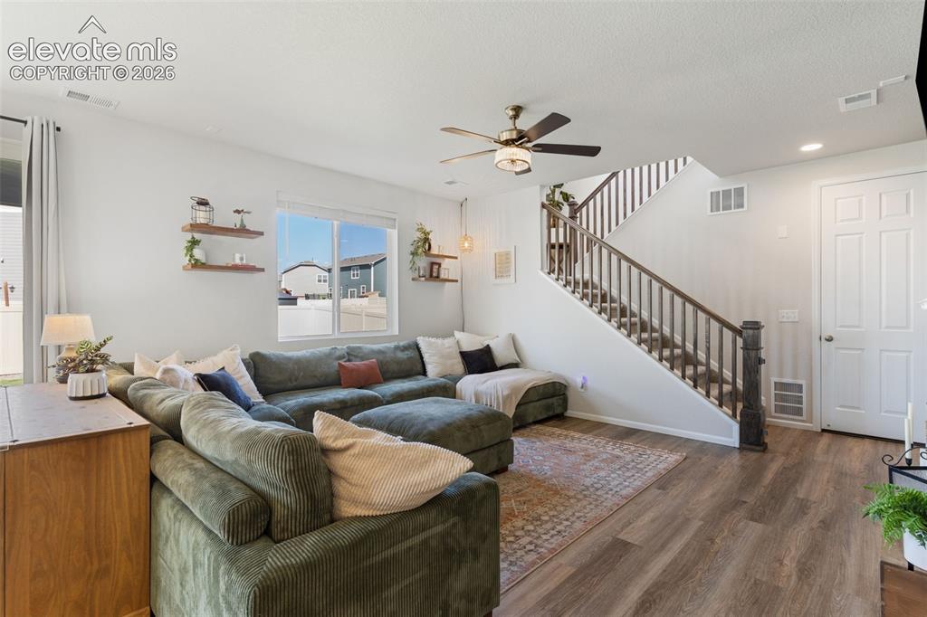 Image 11 of 33: Living area featuring wood-finish flooring, a contemporary ceiling fan, and