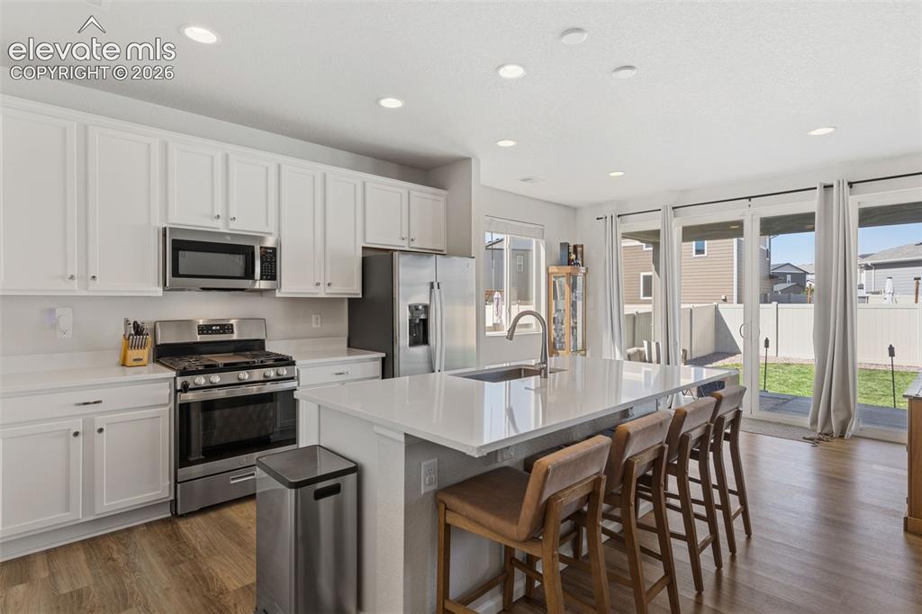 Image 13 of 33: Contemporary kitchen featuring a large center island with integrated sink,