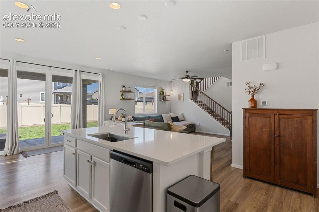 Image 14 of 33: Kitchen island with an undermount sink, stainless steel dishwasher, and whi