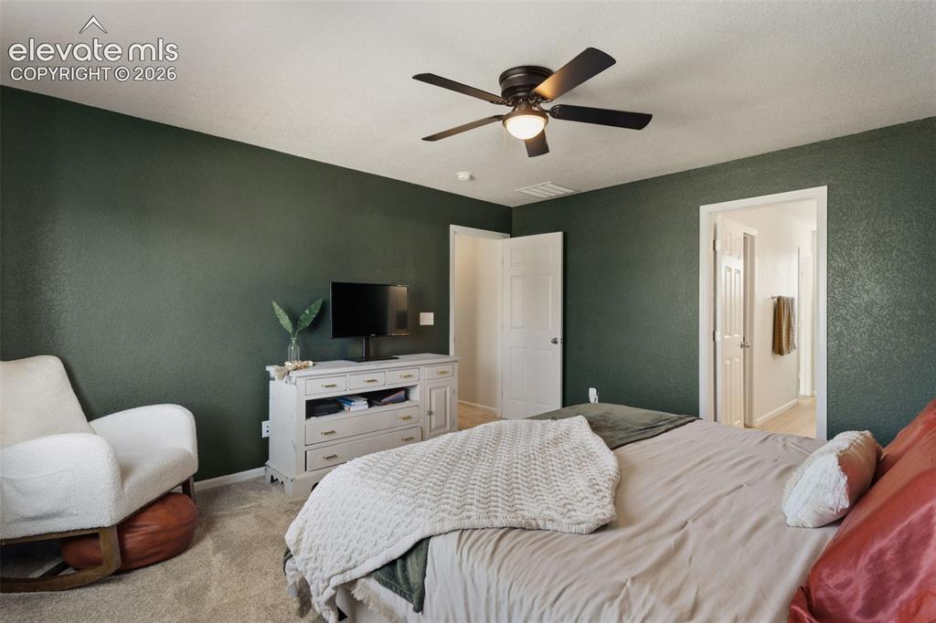 Image 19 of 33: Interior room featuring textured walls, a ceiling fan with light fixture, a