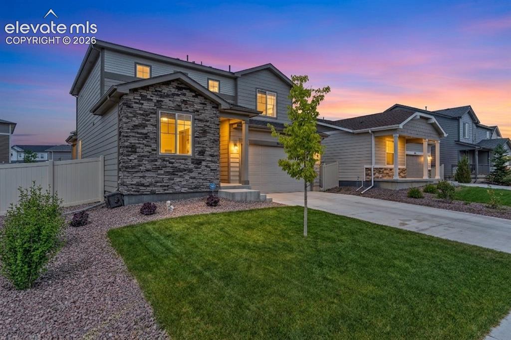 Image 2 of 33: Two-story facade featuring stone and horizontal siding accents, an attached