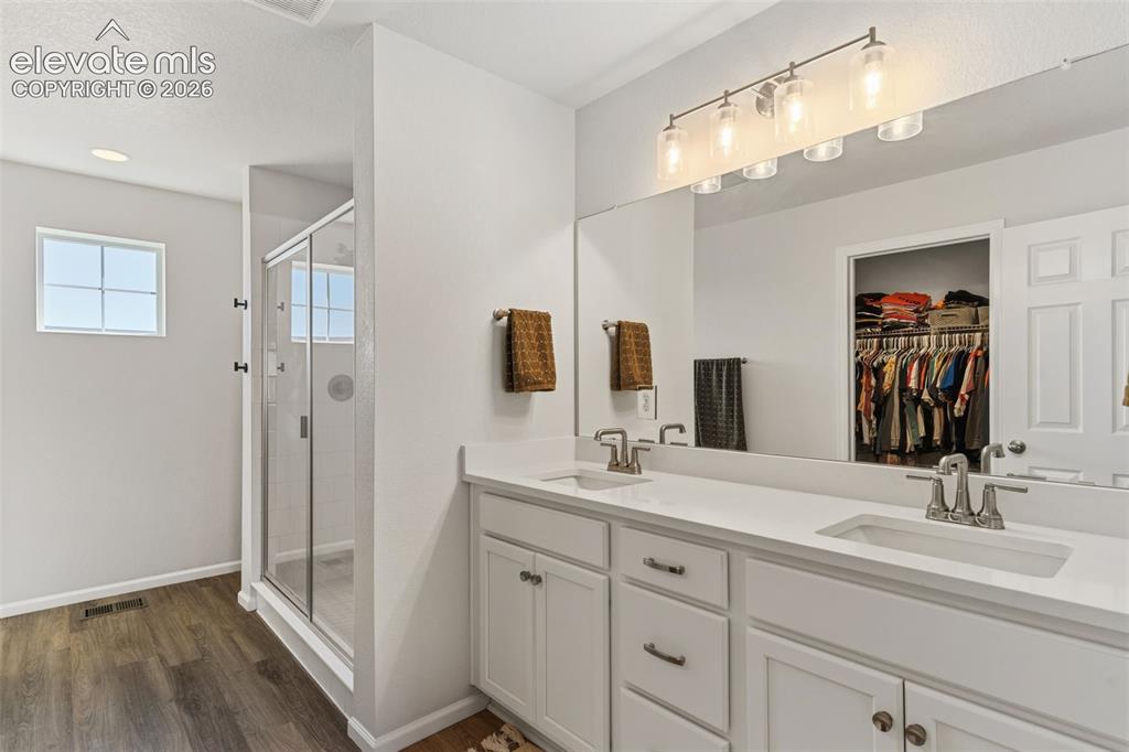 Image 21 of 33: Spacious bathroom featuring a dual vanity with white cabinetry and an expan
