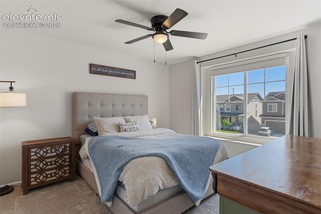 Image 22 of 33: Bedroom featuring a large window, a ceiling fan with integrated lighting, a