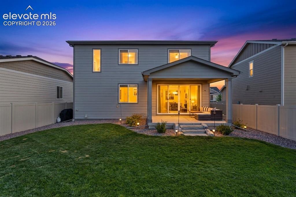 Image 4 of 33: Two-story residence featuring a covered patio, sliding glass doors, a manic