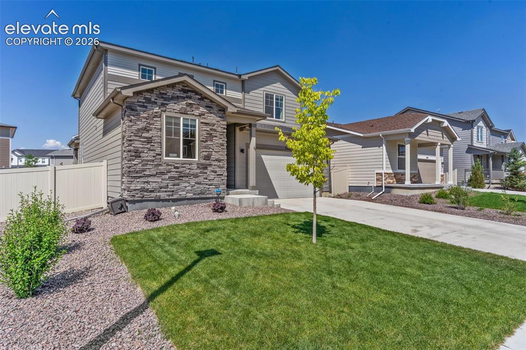Image 6 of 33: Two-story residence featuring a stone and siding exterior