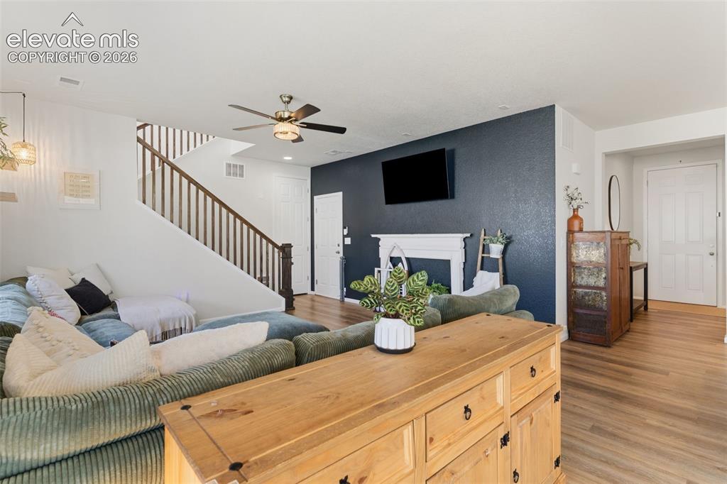 Image 9 of 33: Living area featuring wood-finish flooring, a white mantelpiece, and a cont