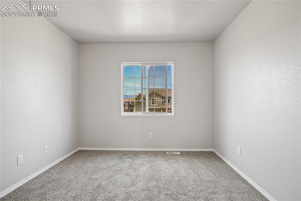 Image 26 of 45: Spare room featuring baseboards and carpet flooring