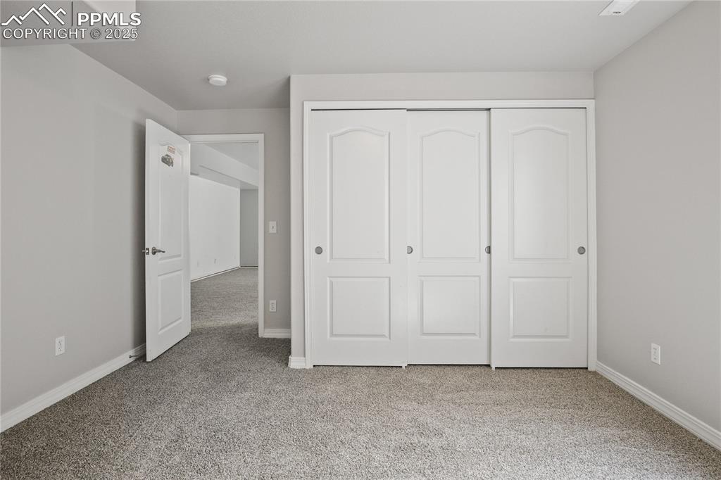 Image 34 of 45: Unfurnished bedroom with baseboards, a closet, and carpet flooring