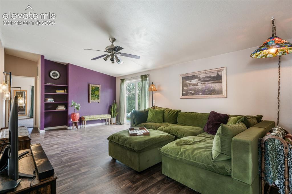 Image 9 of 50: Spacious interior featuring LVP, a vibrant accent wall with integrated shel