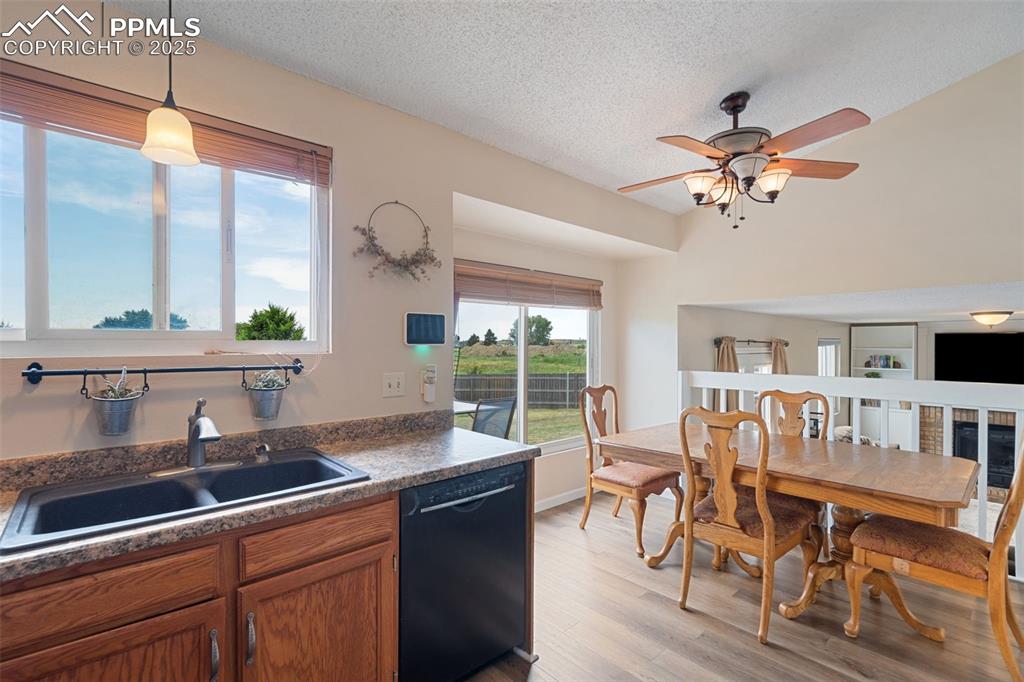Image 14 of 33: Kitchen featuring black dishwasher, ceiling fan, light wood-type flooring, 