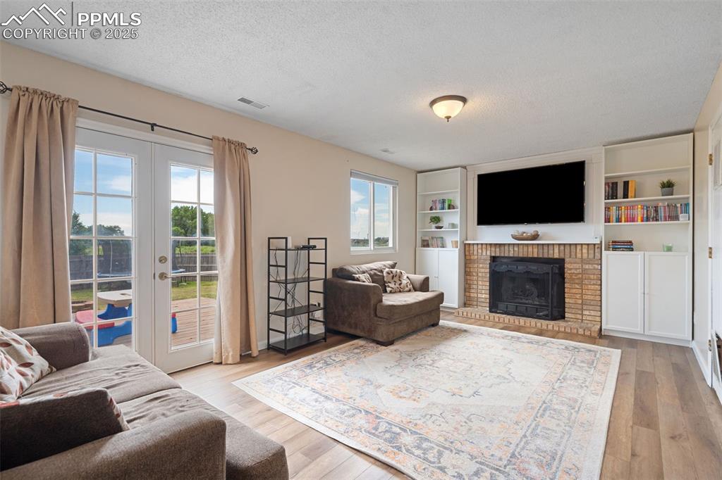 Image 17 of 33: Living room with a textured ceiling, plenty of natural light, french doors,