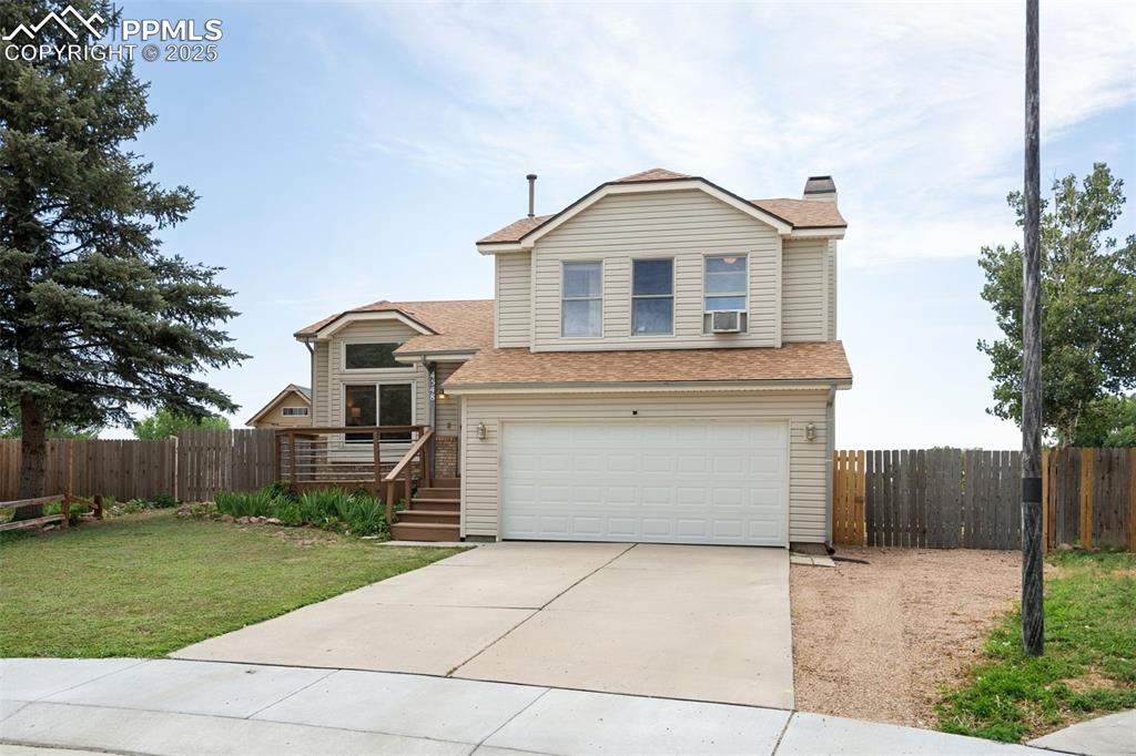 Image 2 of 33: Traditional home with an attached garage, driveway, a chimney, and roof wit
