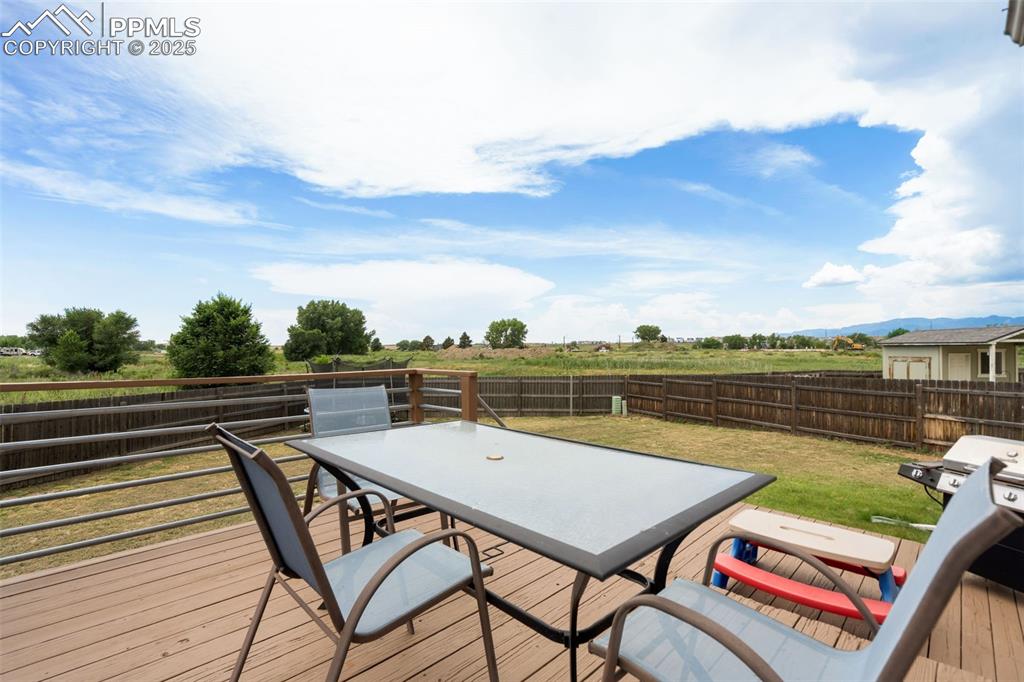 Image 26 of 33: Deck featuring outdoor dining space, a fenced backyard, and grilling area