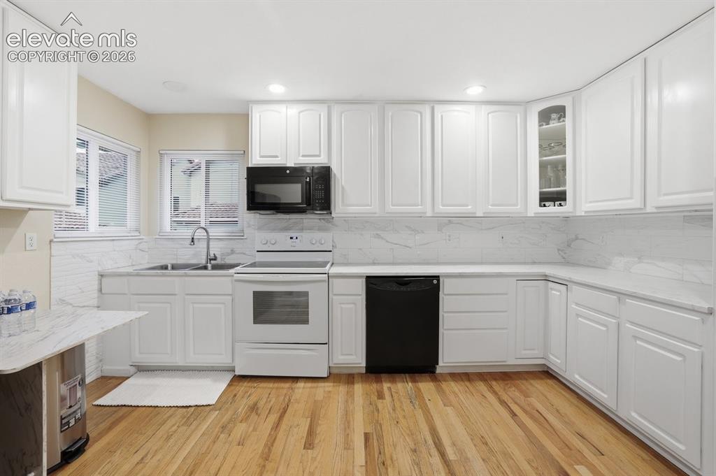 Image 10 of 45: Kitchen featuring light wood-finish flooring, white cabinetry, integrated w