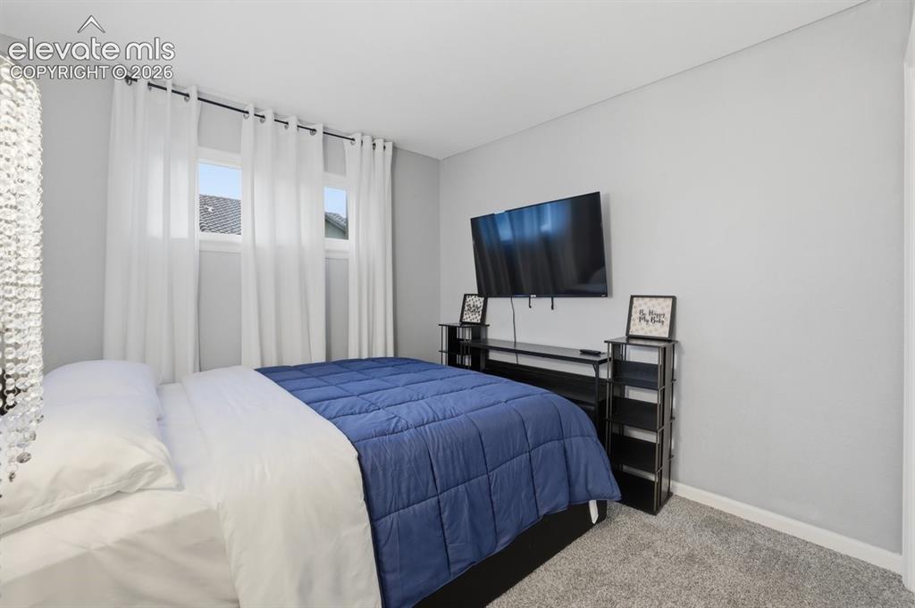Image 15 of 45: Carpeted room featuring multiple windows with white drapery