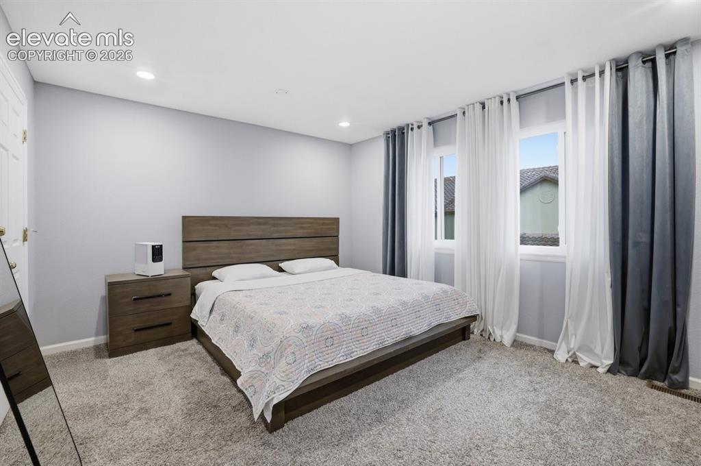 Image 19 of 45: Expansive primary suite featuring plush carpeting, recessed lighting, and d