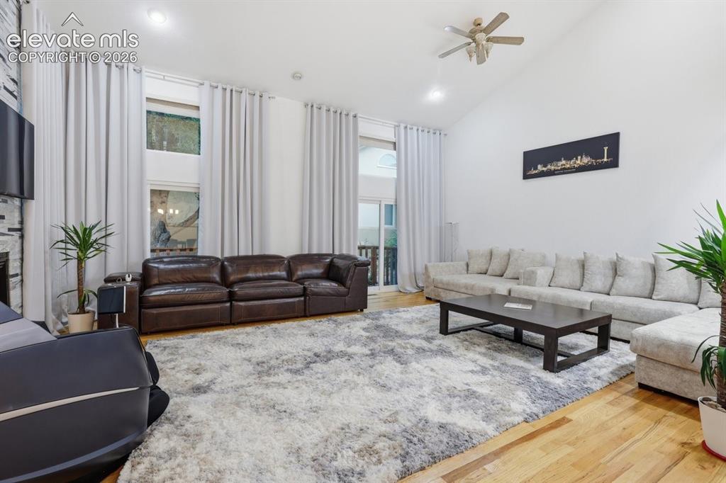Image 2 of 45: Grand living area with soaring vaulted ceilings, recessed lighting, and bea