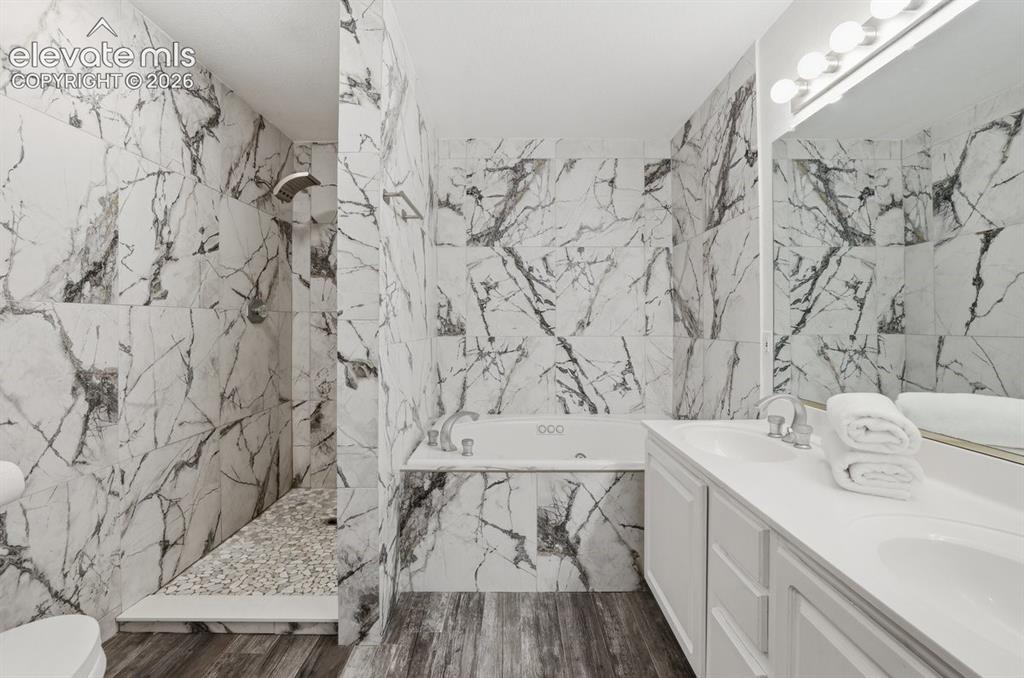 Image 23 of 45: Thoughtfully designed primary ensuite featuring a walk-in shower with pebbl