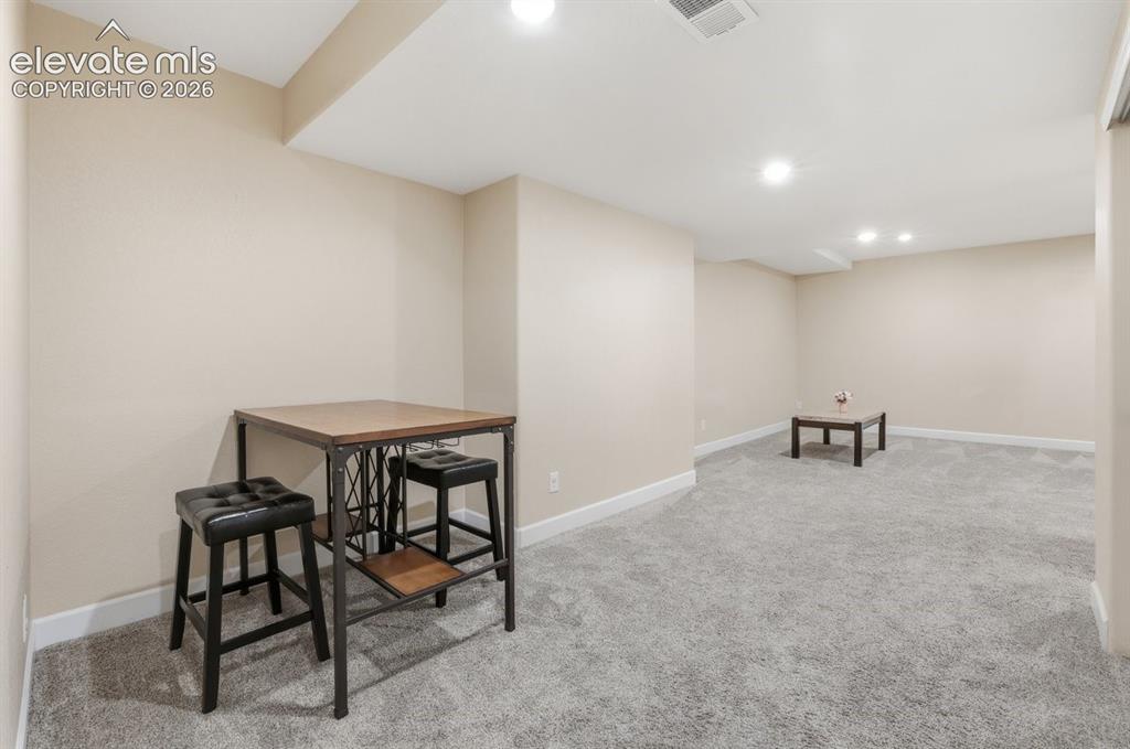 Image 26 of 45: Expansive finished basement offering plush carpeting, recessed lighting, ne