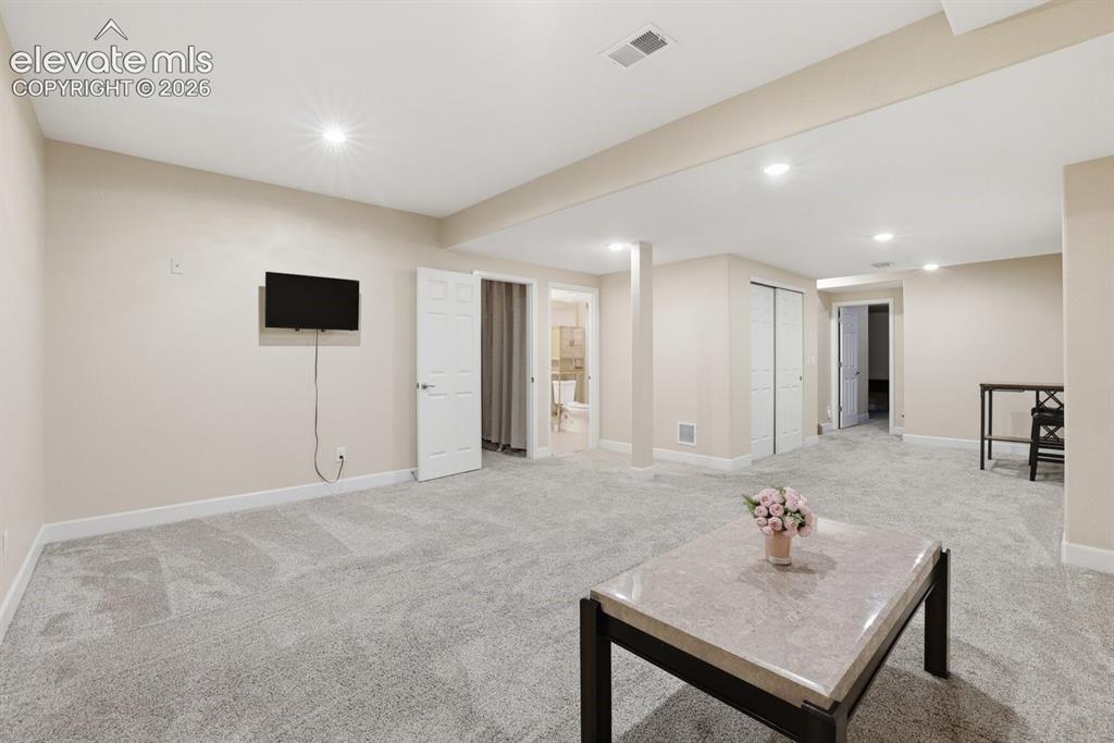Image 28 of 45: Another view of the expansive finished basement showcasing its open layout,