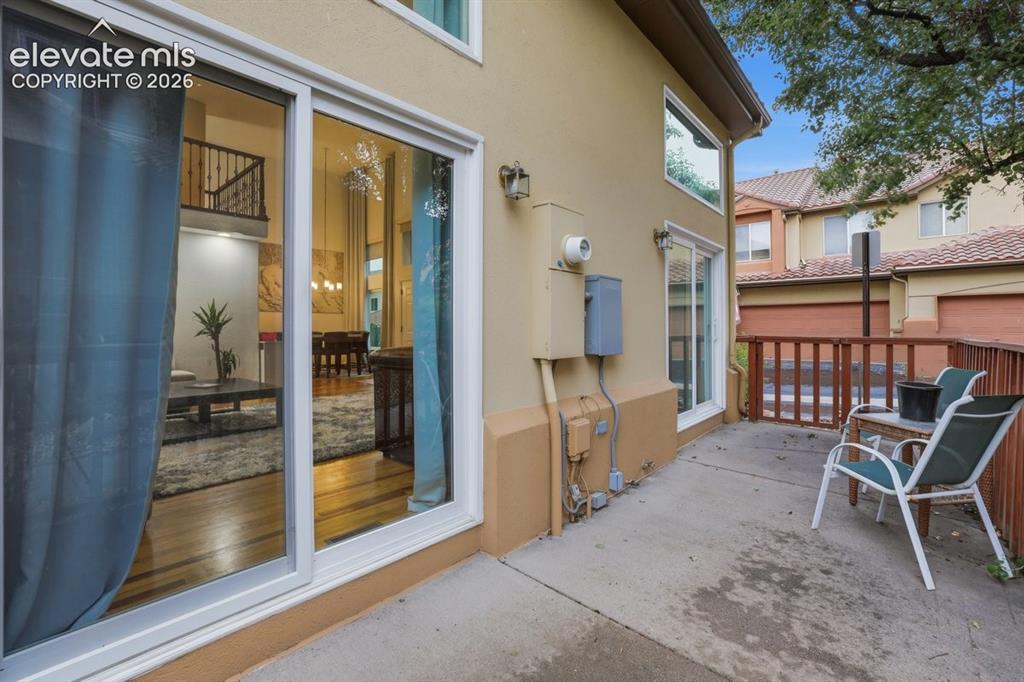 Image 35 of 45: Private outdoor patio with concrete flooring, wood railing, and direct acce