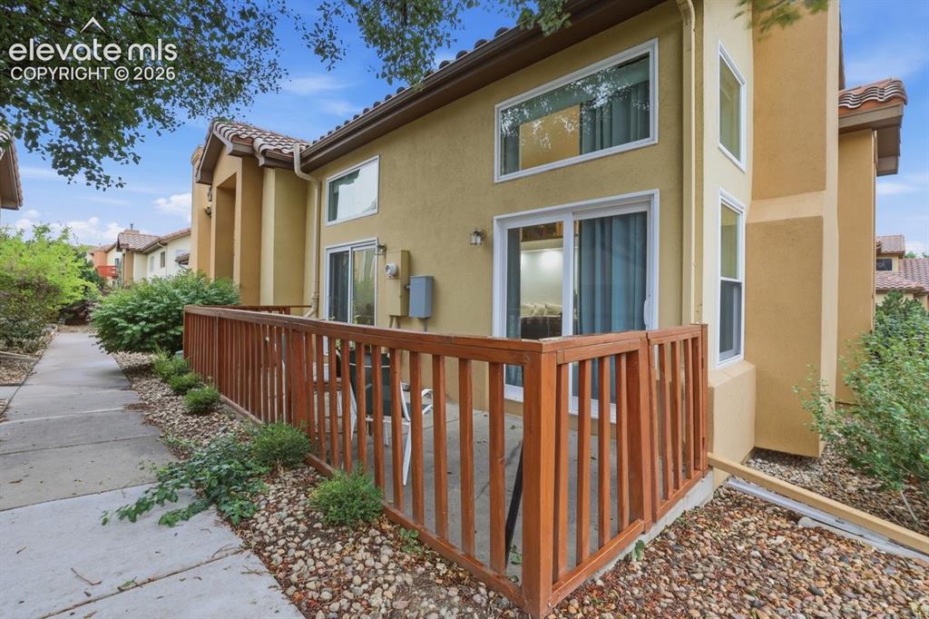Image 36 of 45: Another view of the private patio featuring wood railing and sliding glass