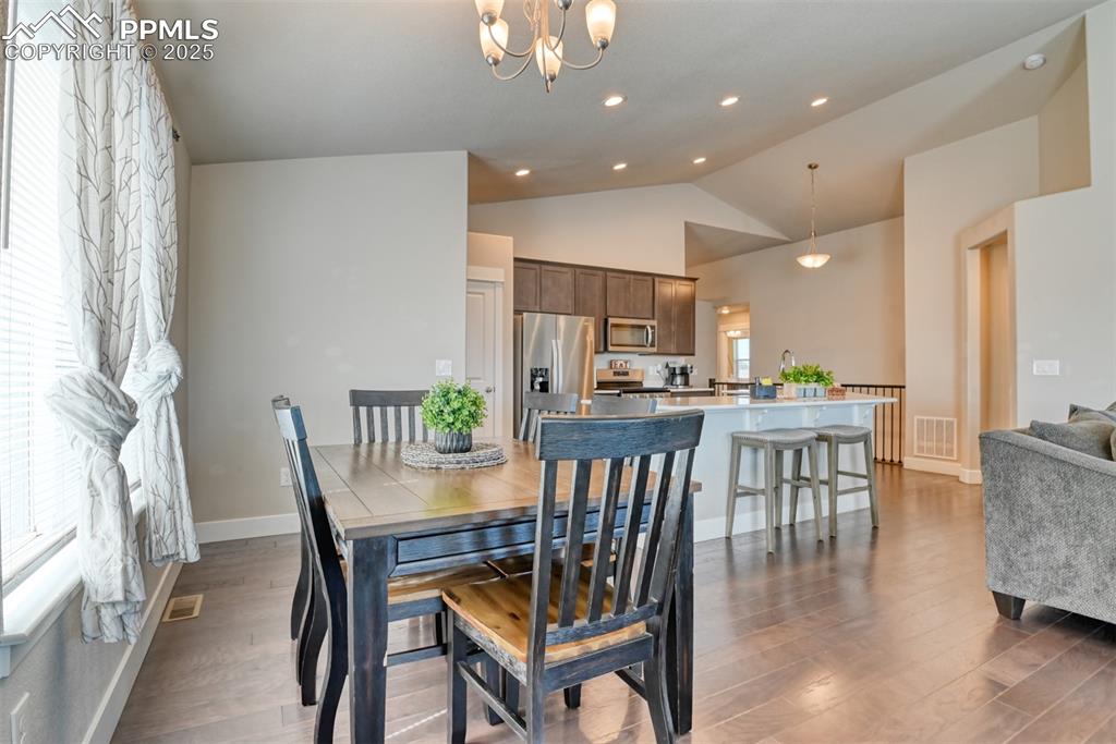 Image 12 of 45: Dining area with light wood-style floors, a chandelier, recessed lighting,