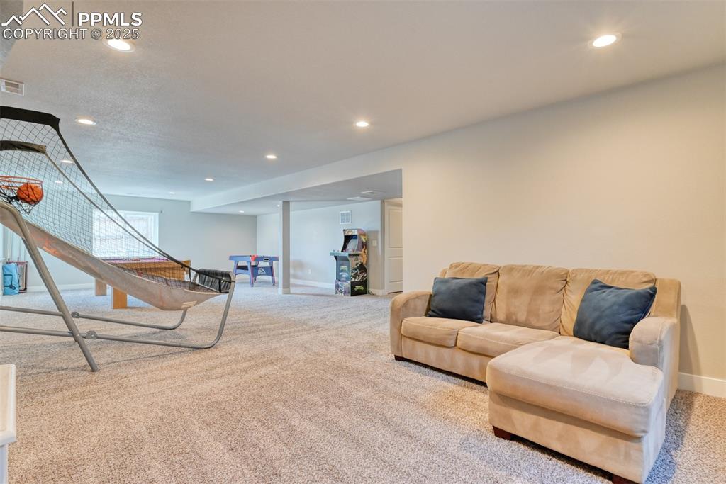 Image 30 of 45: Living area with carpet floors and recessed lighting