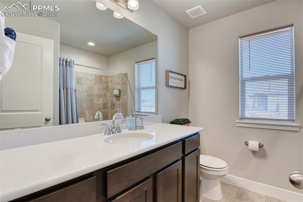 Image 32 of 45: Bathroom with vanity, light tile patterned flooring, a shower with curtain,