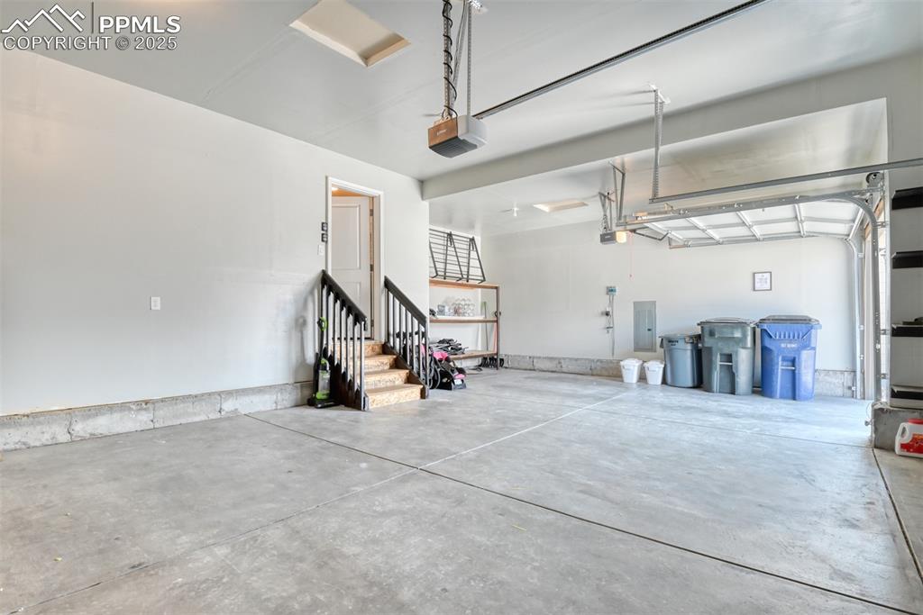 Image 37 of 45: Garage featuring electric panel and a garage door opener